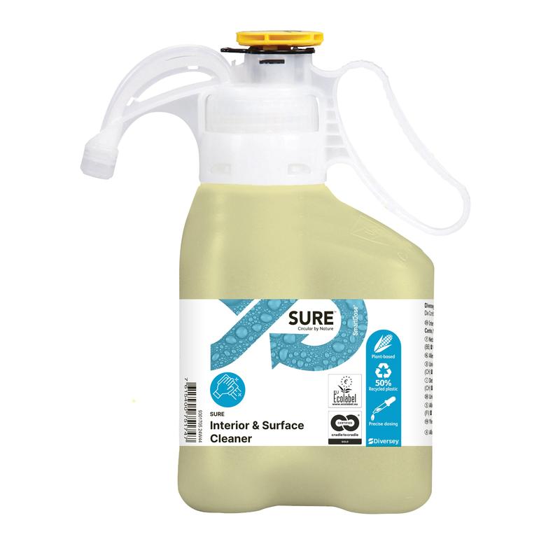 Ein hellgelber SURE Interior & Surface Cleaner Allzweckreiniger von Diversey Deutschland GmbH & Co. OHG in einer griffigen Kunststoffflasche mit Messkappe; etikettiert als umweltfreundlich mit pflanzlichen Inhaltsstoffen, Ökosymbolen, und Anwendungshinweisen.