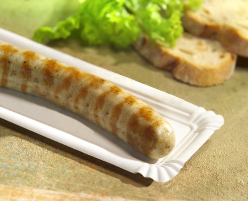 Eine gegrillte Wurst auf einem PAPSTAR 250 Teller, Pappe "pure" eckig weiß von PAPSTAR GmbH, mit Brotscheiben und grünem Salat im Hintergrund auf einer hellen Fläche.