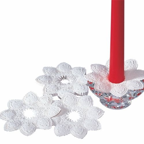 Drei PAPSTAR Kerzen-Manschetten rund Ø 10 cm weiß liegen flach, eine ist um den Fuß einer roten Stabkerze im Glas-Kerzenhalter – ideal für professionelle Anwender und stilvolle Anlässe (100 Stück, PAPSTAR GmbH).
