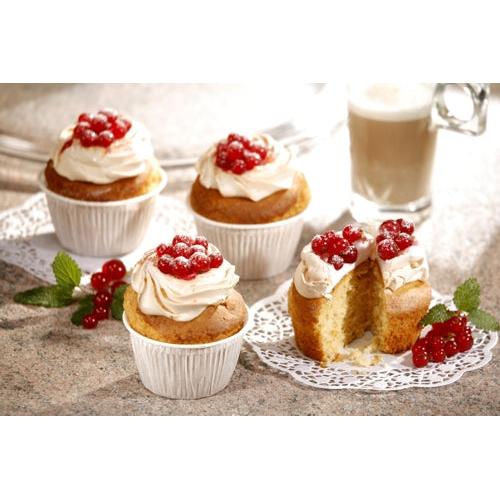 Vier kleine Muffins mit leichtem Zuckerguss und roten Beeren, arrangiert auf Steingut, präsentieren die PAPSTAR 20 Muffins-Backförmchen Ø 5 cm · 3,5 cm weiss (20 Stück) der PAPSTAR GmbH. Ein Latte Macchiato und grüne Blätter runden die gemütliche Backliebhaber-Szene ab.