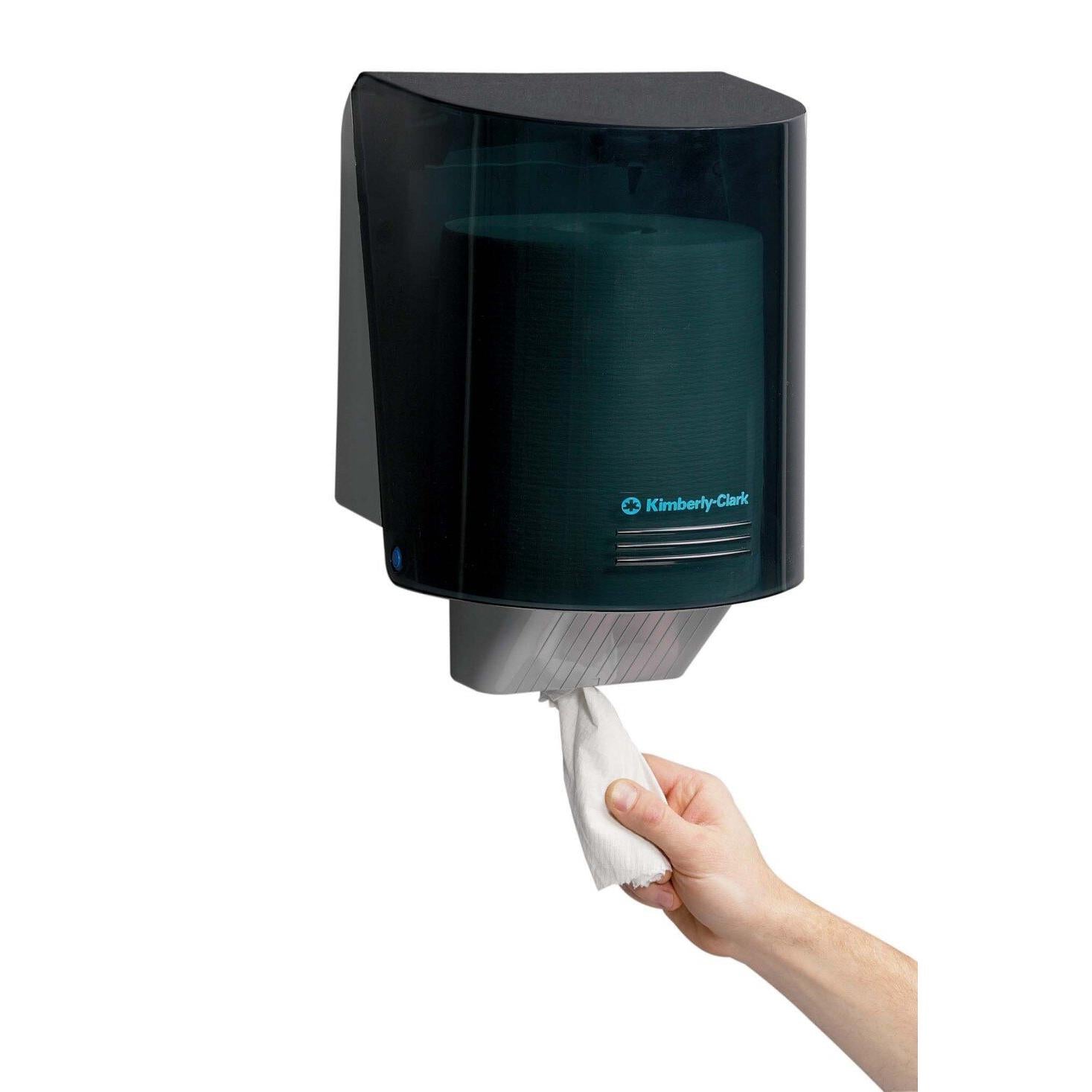 Eine Hand zieht ein Handtuch aus dem Kimberly-Clark Professional™ Wischtuch-Spender - Zentralentnahme / Grau von Kimberly-Clark GmbH und sorgt so für hygienische Wischtuchentnahme bei jedem Gebrauch.