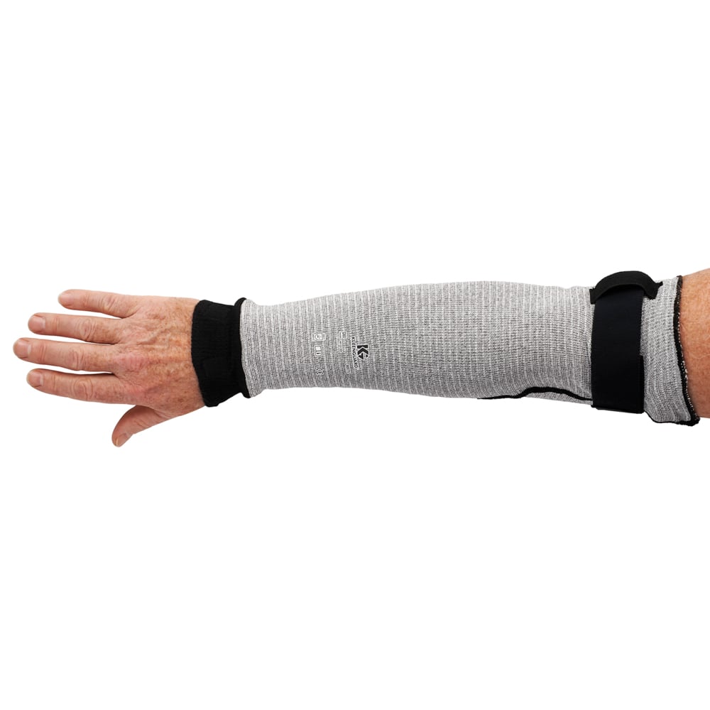Der linke Arm einer Person trägt einen grauen KleenGuard® G60 Endurapro™ Schnittfeste Handschuhe Level 5 Ärmel (18") der Kimberly-Clark GmbH, der vom Handgelenk bis oberhalb des Ellenbogens reicht und mit schwarzen Bändern am Handgelenk und Oberarm befestigt ist.