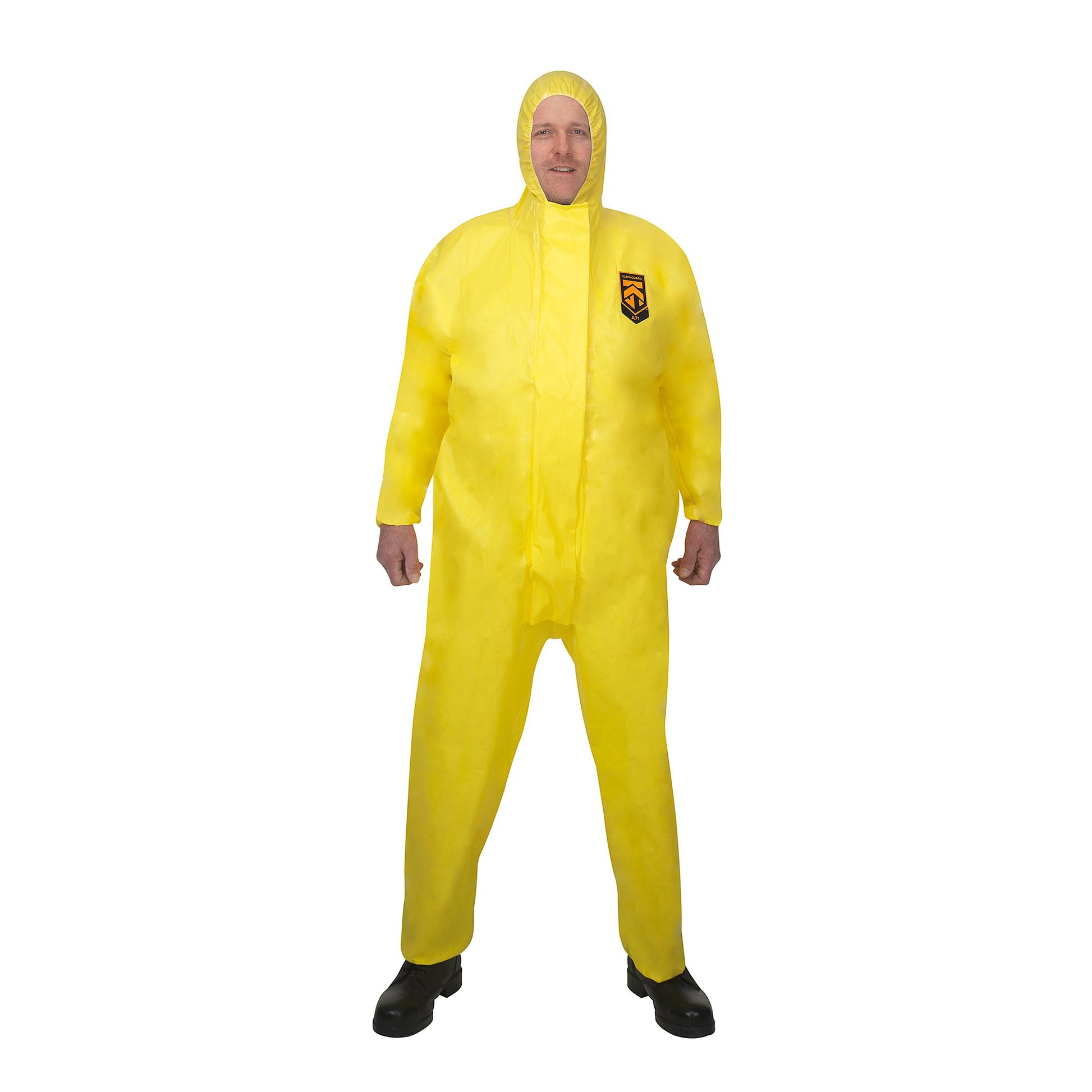 Eine Person steht mit dem Gesicht nach vorne in einem leuchtend gelben Kimberly-Clark GmbH KleenGuard® A71 Schutzanzug gegen Chemikalien-Sprühnebel mit Kapuze und schwarzen Stiefeln, mit einem kleinen Brustlogo, auf einem einfarbig weißen Hintergrund.