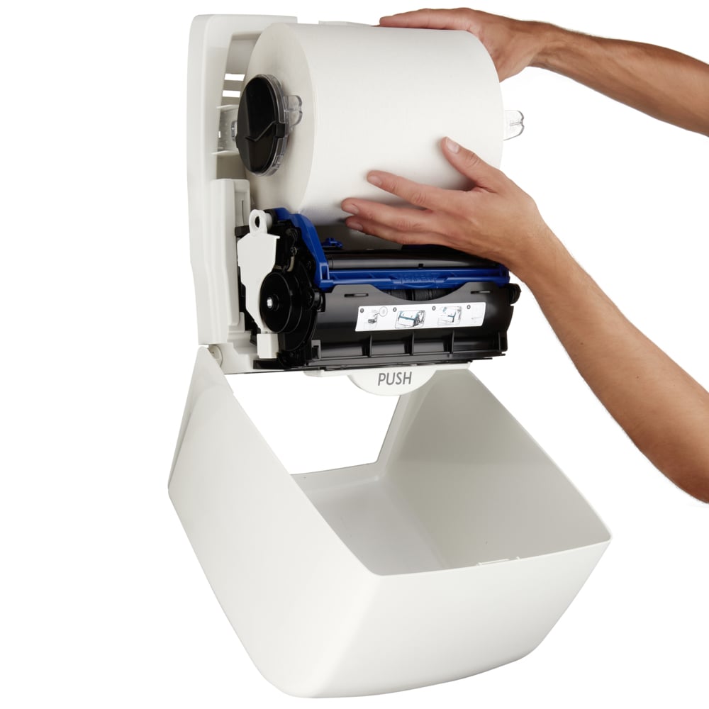 Eine Person installiert eine große Papierhandtuchrolle in den Aquarius™ Rollenhandtuchspender - Weiß von Kimberly-Clark GmbH mit sichtbarem Mechanismus - ideal für öffentliche, hygienisch anspruchsvolle Bereiche.