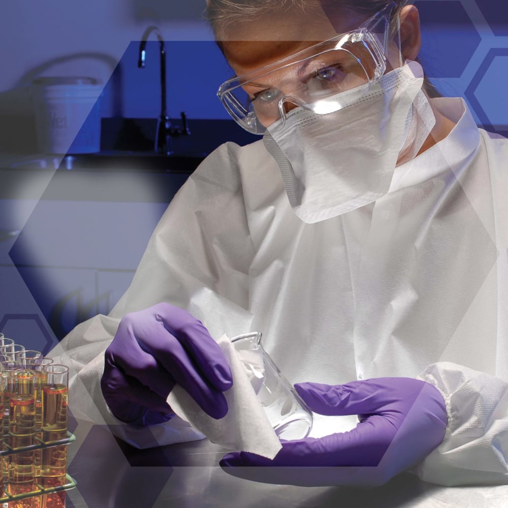 Ein Wissenschaftler mit Schutzbrille, Maske und lila Handschuhen wischt einen Laborkolben mit Kimtech® Science Präzisionstüchern von Kimberly-Clark GmbH ab. Reagenzgläser und sechseckige Grafiken erscheinen auf dem Tisch. Produkt: 30 Kartons x 286 Blatt pro Karton.