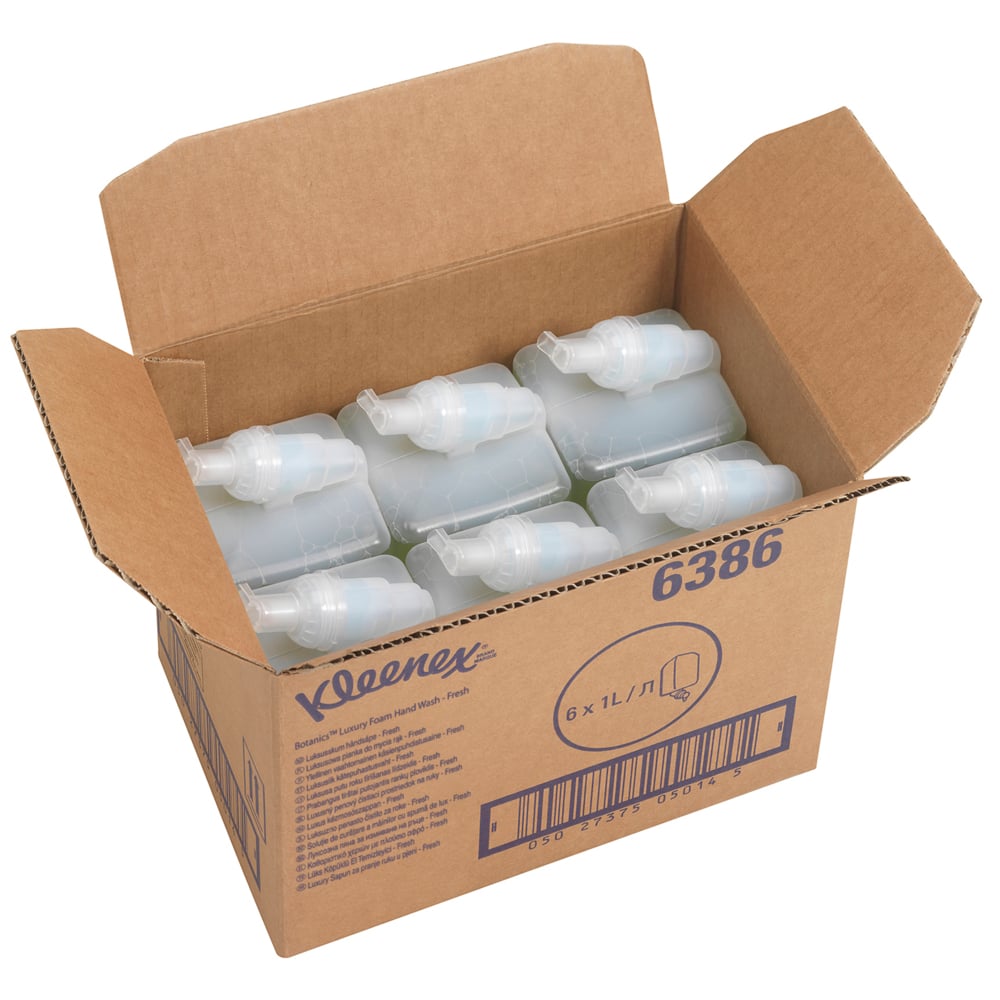 Eine geöffnete Schachtel mit der Aufschrift "Kleenex® Botanics™ Luxury Foam Hand Wash - 1L Kassette" von Kimberly-Clark GmbH enthält sechs grüne 1L-Kassetten, Informationen und einen Barcode. Die Schachtel hebt Schaumseife mit botanischen Extrakten hervor.