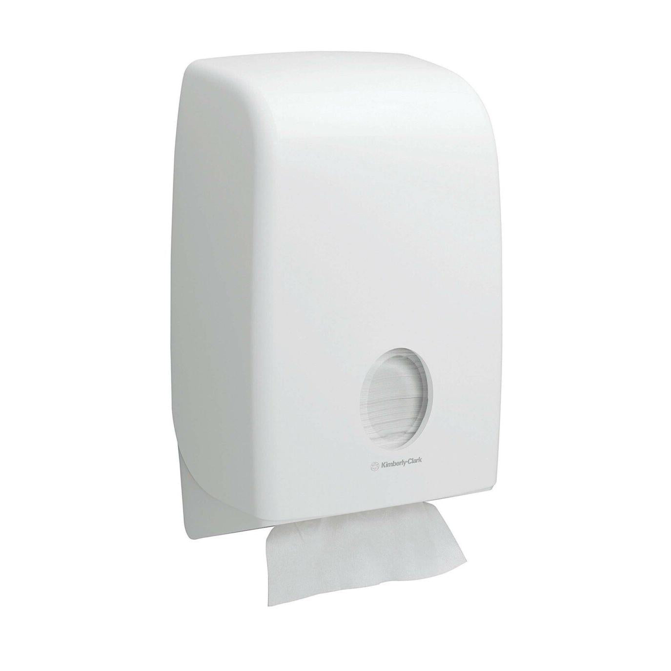 Ein weißer, an der Wand montierter Kimberly-Clark Scott® Essential™ Handtuchspender mit rundem Fenster zeigt im Inneren Falthandtücher (Weiß, Klein, 15 Clips x 340 Blatt) und ein Handtuch, das zum hygienischen Händetrocknen teilweise ausgegeben wird.