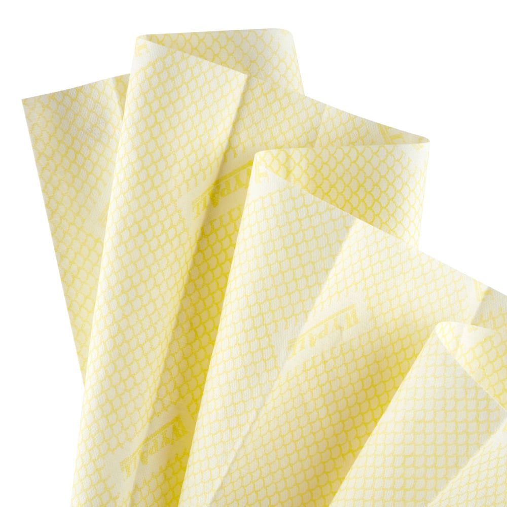 Eine Nahaufnahme von mehreren hellgelben WypAll® X80 Critical Clean - Interfold Tüchern (41,00 cm x 33,00 cm) von Kimberly-Clark GmbH, mit einem dezenten geometrischen Muster, geschichtet auf weißem Hintergrund. Ideal für die industrielle Reinigung.