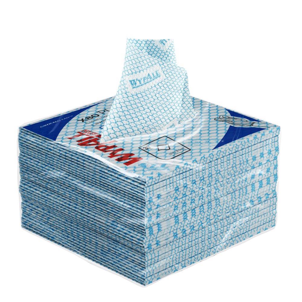 Ein Stapel blauer WypAll® X80 Plus Critical Clean Tücher von Kimberly-Clark GmbH, viertelgefaltet, liegt im Karton (8 Beutel x 30 Tücher), ein Tuch teilweise aus dem oberen Schlitz gezogen.