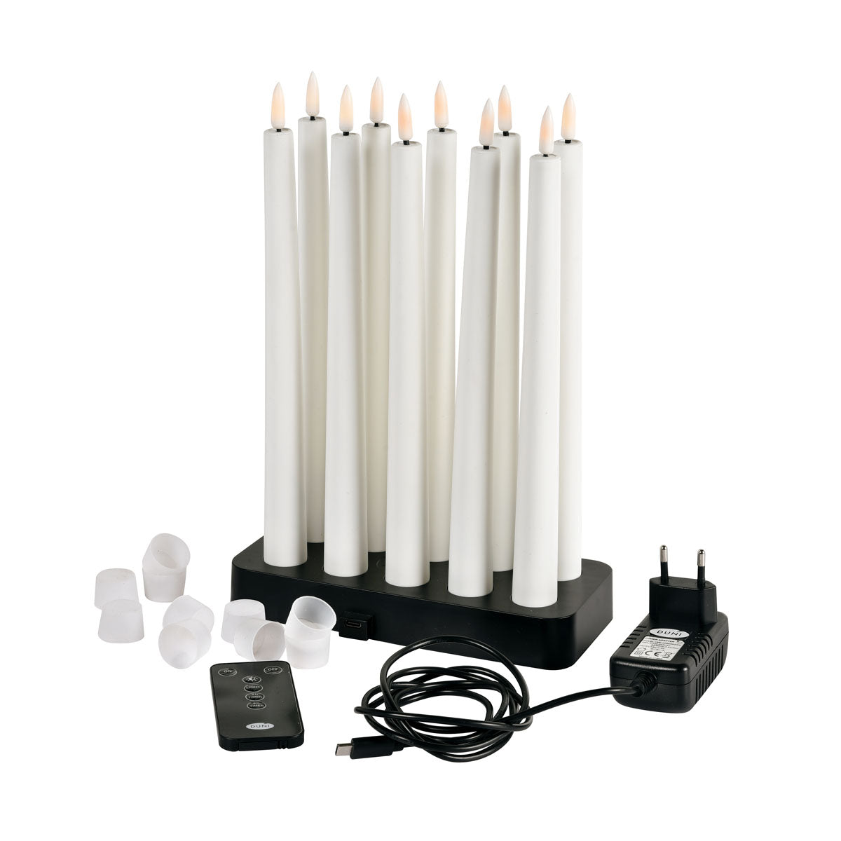 Das Duni GmbH LED Spitzkerzen 27,8cm, 10er, warmweiss Set kommt in einer Box mit schwarzer Ladestation, Netzteil, USB-Kabel, Fernbedienung und weißen Kerzenkappen - alles fein säuberlich auf einer weißen Fläche angeordnet.
