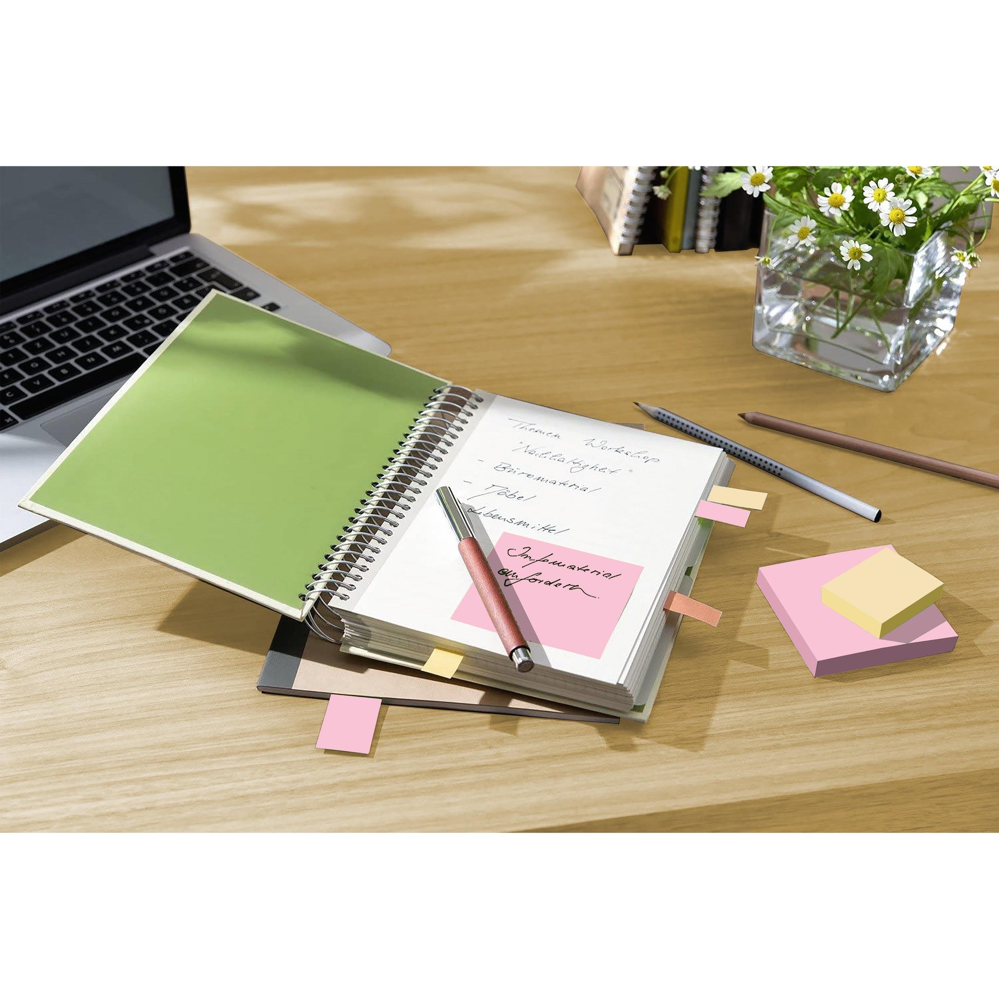 Ein aufgeschlagenes Spiralnotizbuch mit handschriftlichen Notizen und 3M Post-it® Recycling Notes (76x127 mm, 100 Blatt, PEFC-zertifiziert) liegt auf einem Holztisch neben einem Laptop, einem Bleistift, weiteren Haftnotizen und einer Glasvase mit weißen und gelben Blumen.