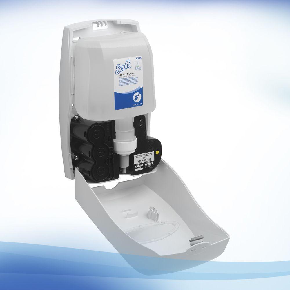 Ein wandmontierter Seifenspender mit geöffneter Front zeigt eine Scott® Control™ Schaum-Handreiniger-Nachfüllung der Kimberly-Clark GmbH. Er ist vor einem weiß-blauen Hintergrund mit Farbverlauf abgebildet und eignet sich ideal für Handhygieneprotokolle. Die Box enthält 4 Patronen.