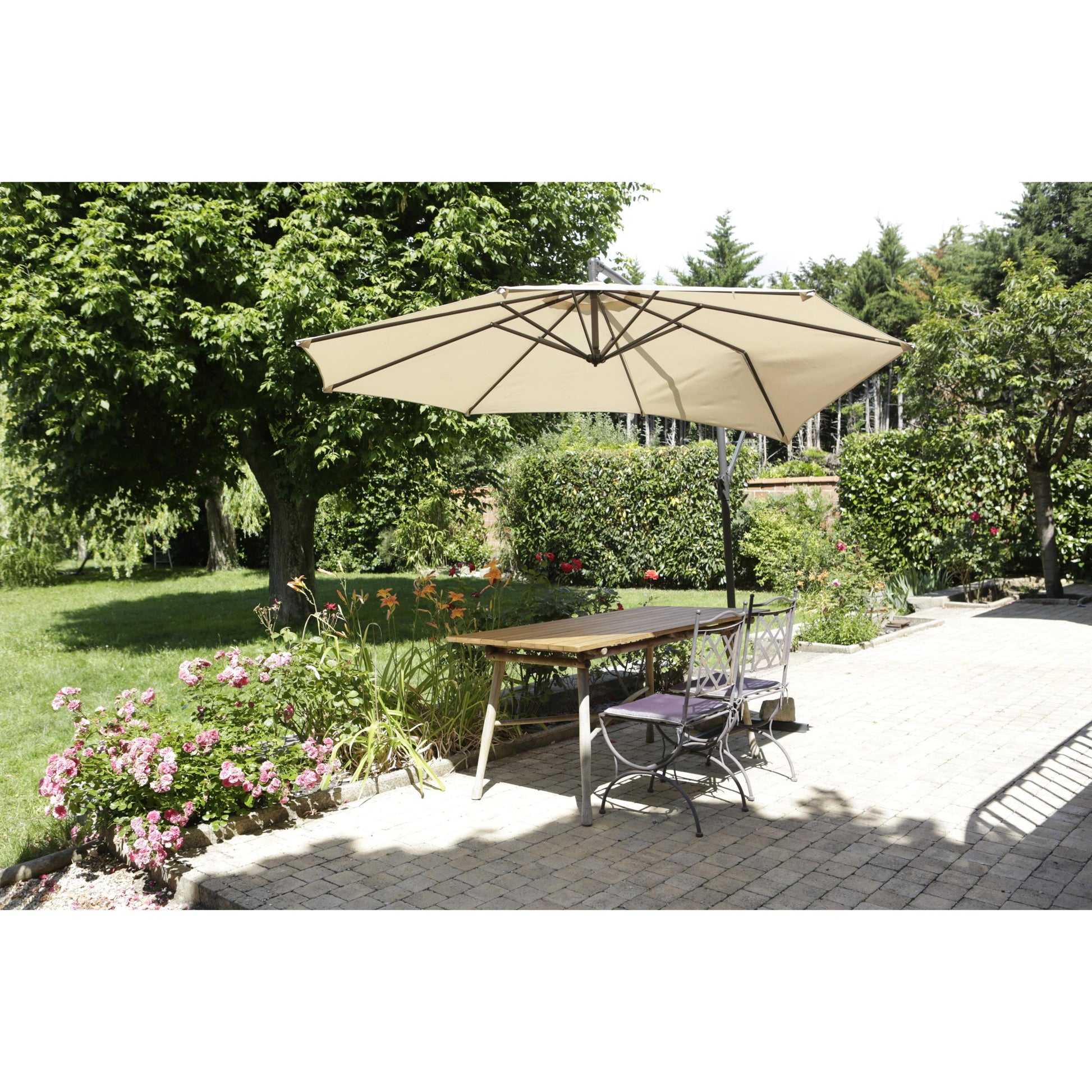 Eine Terrasse mit einem Holztisch, zwei Metallstühlen und einem großen beigen Sonnenschirm ist von Grün umgeben - und zeigt das Scotch® Extremium™ Ultra Hochleistungs-Klebeband DT17 der 3M Deutschland GmbH für den extremen Außeneinsatz.