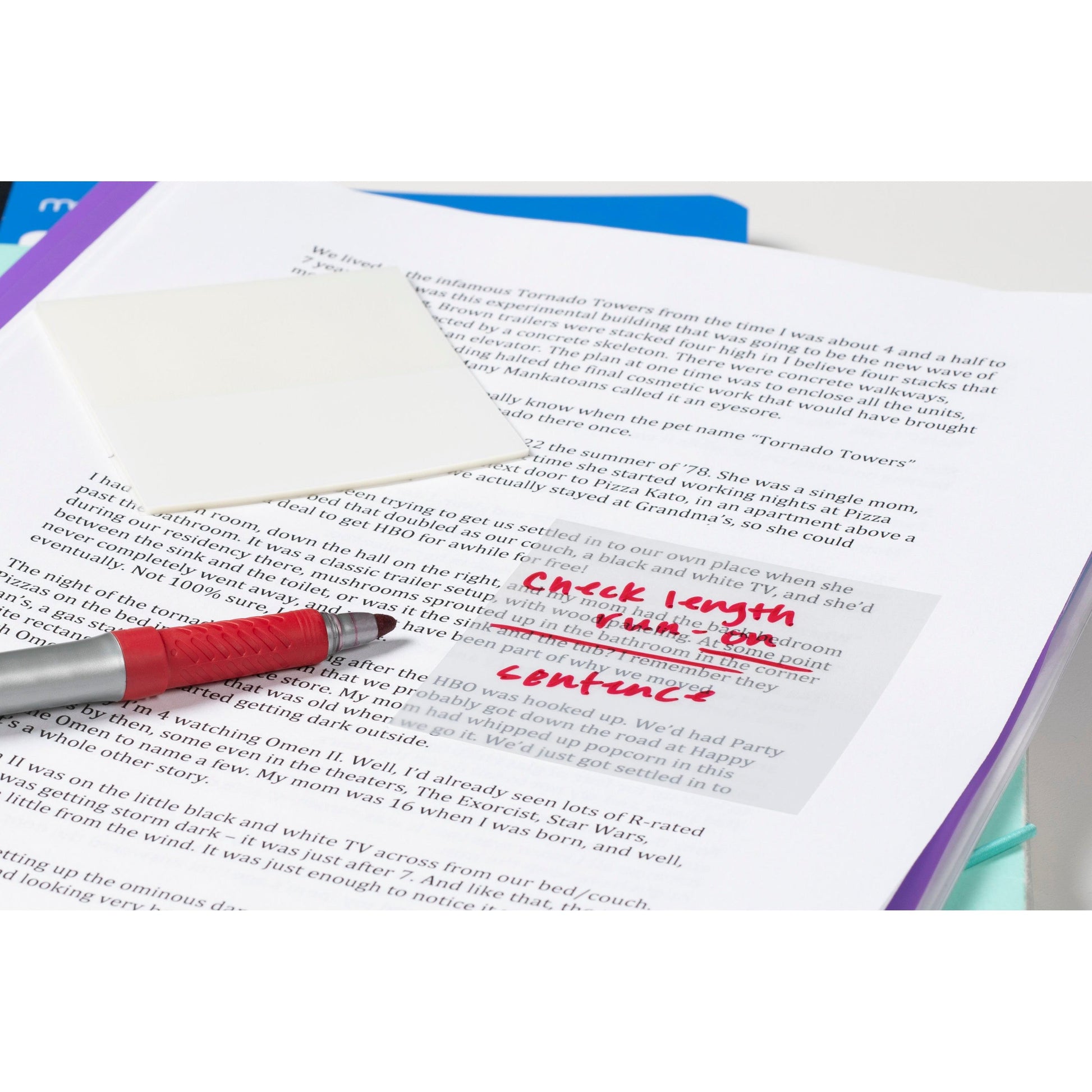 Ein roter Stift liegt auf gedruckten Dokumenten. Ein Post-it® Transparent Zettel (73 x 73 mm, 36 Blatt/Block) der 3M Deutschland GmbH mit handschriftlichen roten Änderungen - "Prüfen Sie die Länge in unserem Inhalt" - liegt über dem Text auf der oberen Seite.