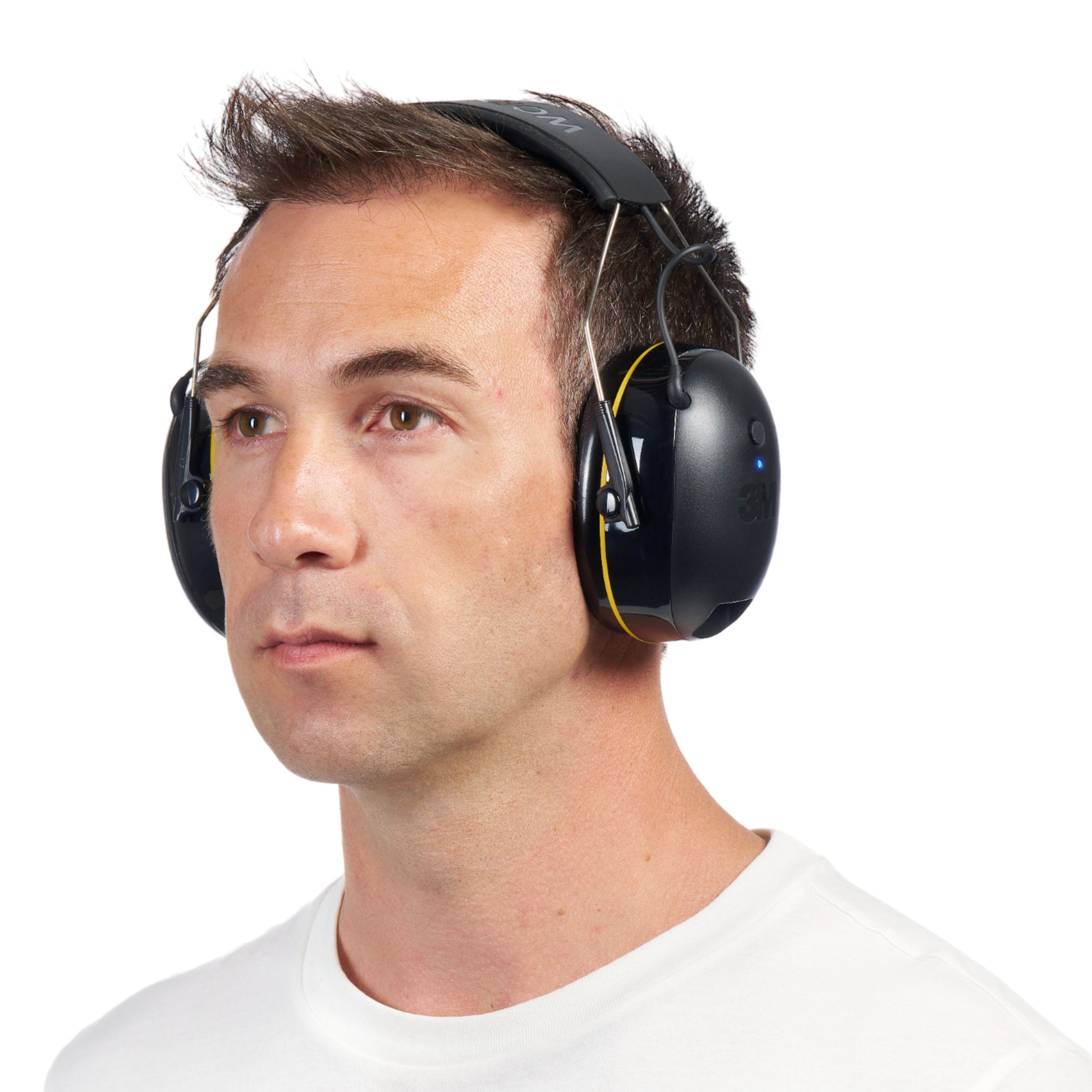 Ein Mann trägt 3M™ WorkTunes™ Connect Kapselgehörschutz 90543E schwarze Bluetooth®-Kapselgehörschützer (SNR 31 dB) von 3M Deutschland GmbH und ein weißes Hemd mit Rundhalsausschnitt vor einem schlichten weißen Hintergrund.