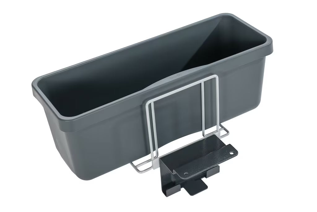 Ein dunkelgrauer rechteckiger Kunststoff-Pflanzkasten mit einer Moppbox Halterung AERO 3500 aus Metall und einer Frontbefestigungsklammer von Diversey Deutschland GmbH & Co. OHG, isoliert auf weißem Hintergrund.