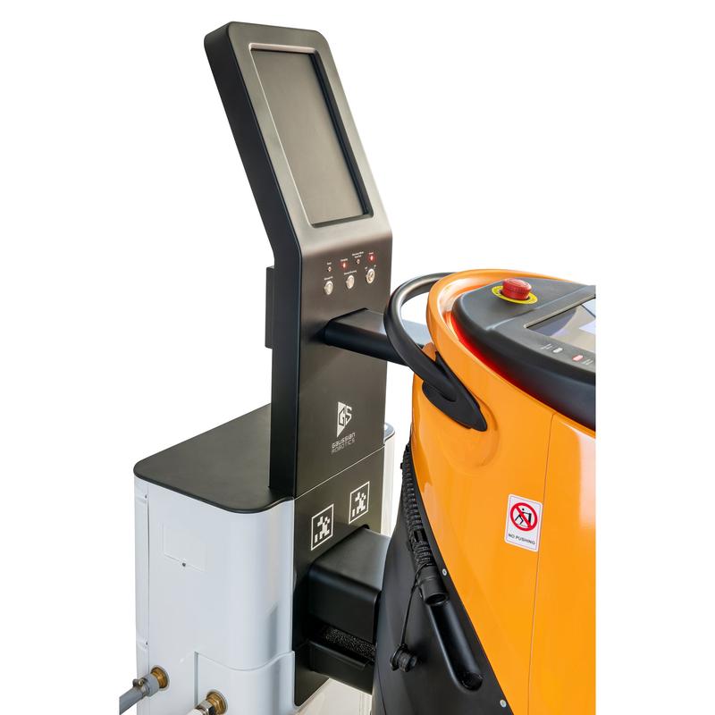Ein Touchscreen-Bedienfeld steht neben einem orange-grauen TASKI GS Ecobot 50P mit Schlauch, Rauchverbotsaufkleber und der TASKI GS Servicestation 50 von Diversey zum kombinierten Aufladen von Strom und Wasser. (1 Packung).
