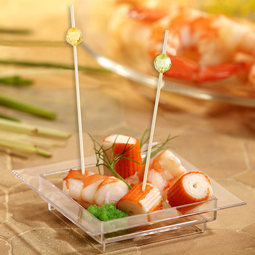 In einer quadratischen, durchsichtigen Kunststoffschale befinden sich Krabbenimitate, grüner Rogen und Dill, serviert mit zwei PAPSTAR 100 Fingerfood - Picker der PAPSTAR GmbH mit runden Spitzen zum einfachen Pflücken.
