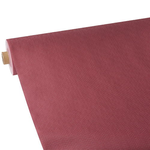 Eine Rolle Starpak Tischdecke, stoffähnlich, Vlies "soft selection plus" von Starpak in einem strukturierten rötlich-braunen Farbton wird teilweise auf einem weißen Hintergrund ausgerollt, wodurch die Oberflächenstruktur und die Farbe des Materials hervorgehoben werden.