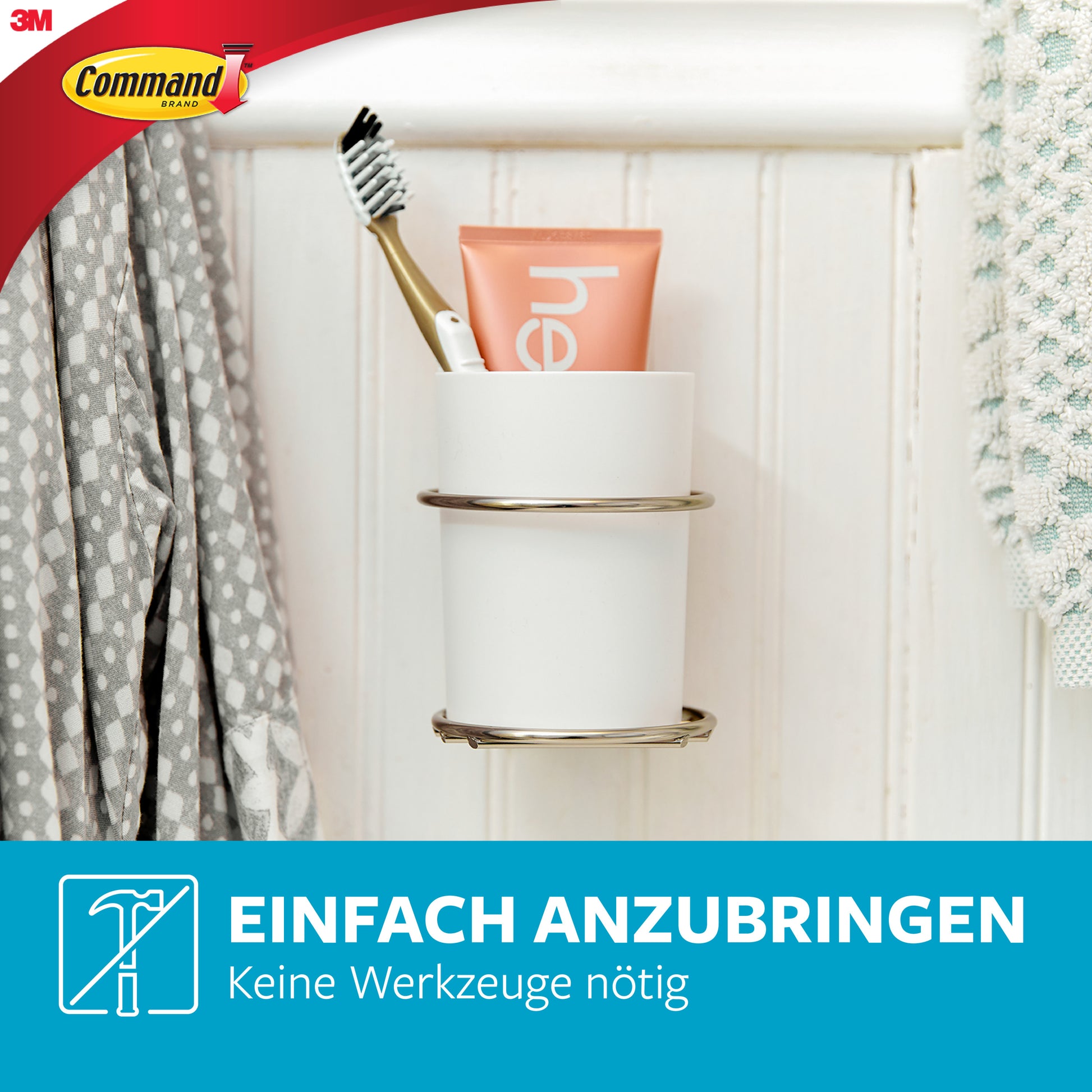 Eine Zahnbürste und Zahnpasta in einem weißen Becher sitzen in einem wandmontierten Metallhalter neben einem Handtuch, mit dem Command™ Metall-Haken Bad (schmal, Satin Nickel) von 3M Deutschland GmbH. Text: "Einfach anzubringen. Keine Werkzeuge nötig.