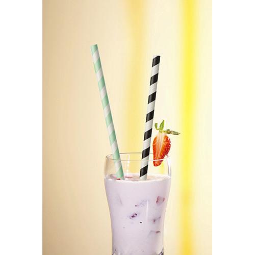 In einem Glas mit rosa Milchshake, Eis, Fruchtstückchen und einer Erdbeergarnitur befinden sich zwei PAPSTAR 100 Trinkhalme Papier Ø 6 mm (by PAPSTAR GmbH), ein grün gestreiftes und ein schwarz gestreiftes.