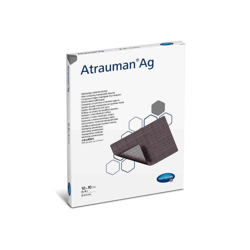 Eine Hartmann Atrauman Ag Salbenkompresse 10x10cm P10 enthält 10 Verbände in einer weißen Schachtel mit sechseckigem Design. Das Logo und Produktdetails der Paul Hartmann AG sind abgebildet, neben einem Bild des teilweise angehobenen Verbandes, das seine Textur und antibakteriellen Eigenschaften zeigt.