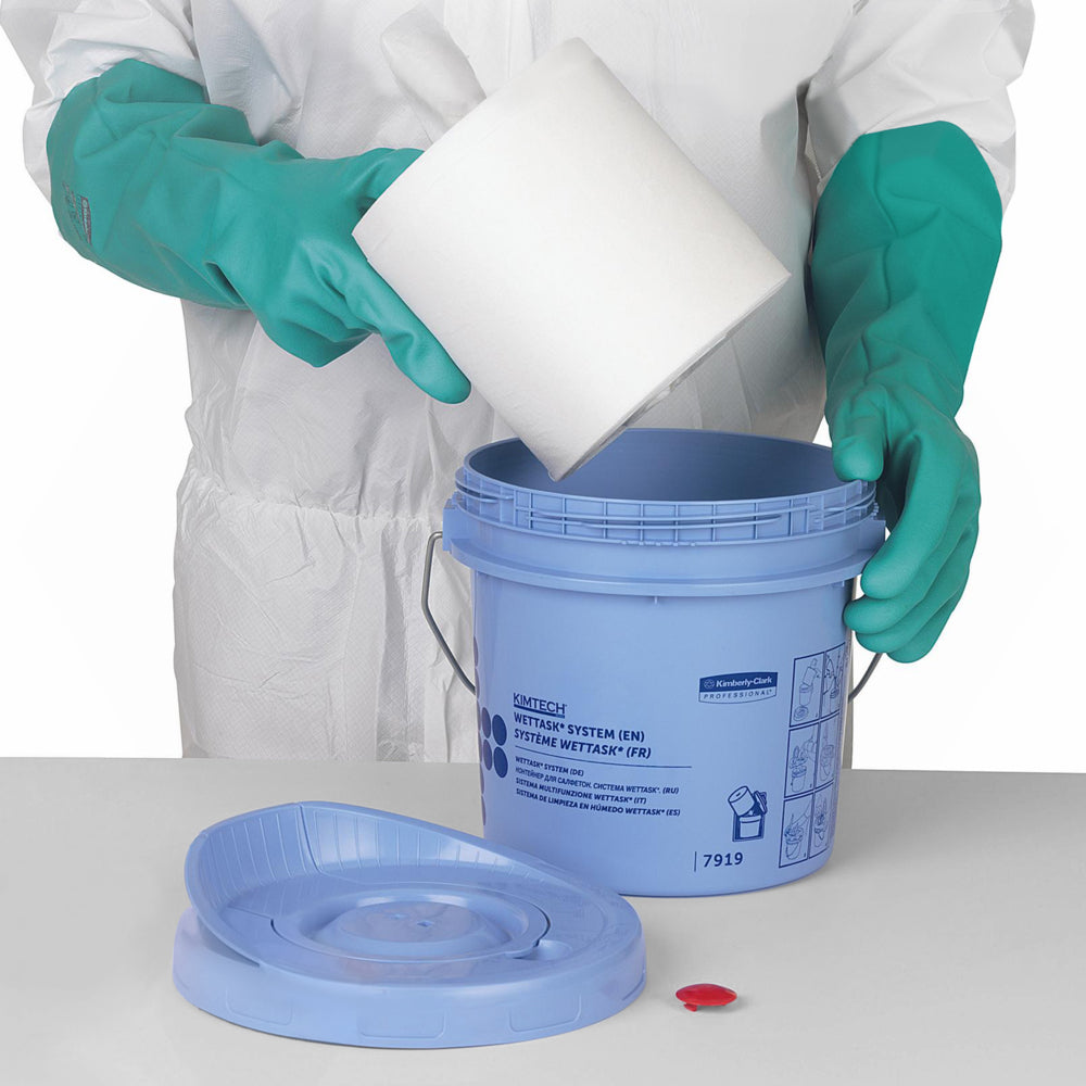 Eine Person in einem weiß-grünen Schutzanzug legt eine weiße Rolle Kimberly-Clark GmbH WypAll® Wettask™ Wischtücher (6 Nachfüllungen x 90 Blatt, Weiß) in einen blauen Eimer.