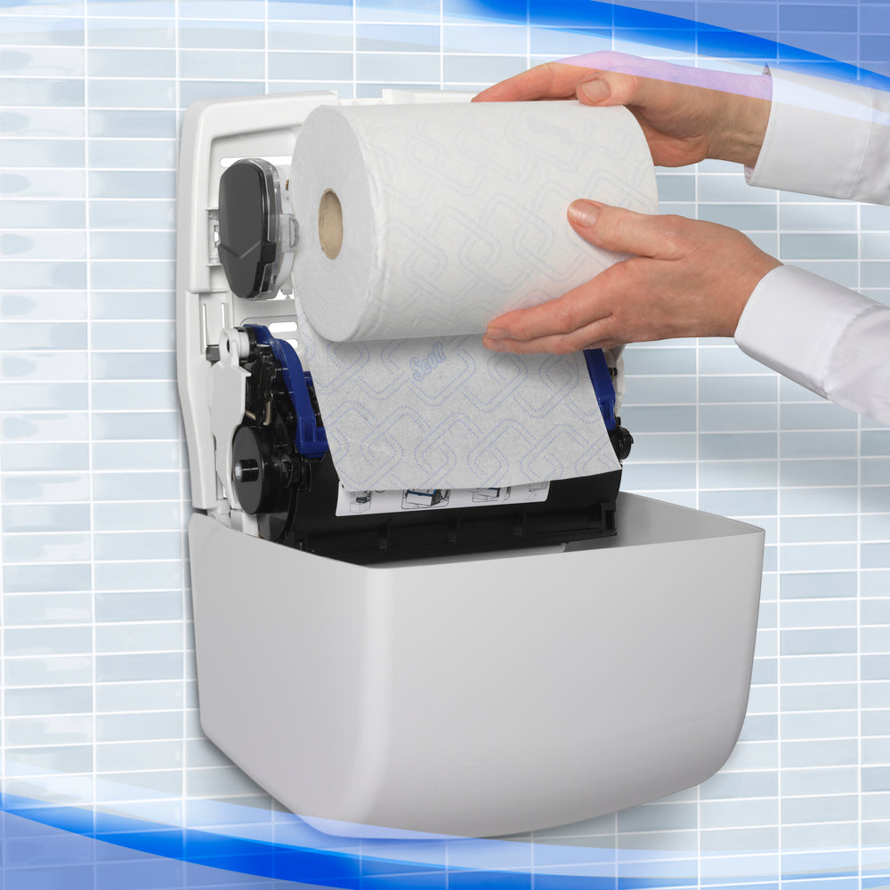 Eine Person lädt eine große Rolle Papierhandtücher in den weißen Aquarius™ Slimroll™ Rollenhandtuchspender der Kimberly-Clark GmbH, der an einer Wand mit einem blau-weißen Kachelmuster im Hintergrund angebracht ist.