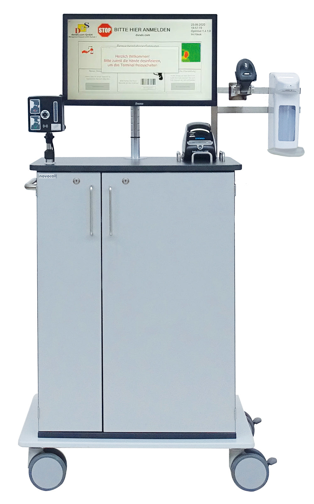 Der Novocal Digitaler Empfangsassistent mit Temperaturmessung ist ein mobiler Medizin-Workstationwagen mit Monitor, Barcode-Scanner, Handdesinfektionsspender, Drucker sowie Besucherregistrierung und zwei Schranktüren auf vier Rollen.