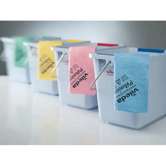 Vier weiße Putzeimer stehen aufgereiht, über deren Rand jeweils ein andersfarbiges Vileda Professional PVAmicro Microfasertuch hängt. Die blauen, rosa, gelben und grünen Tücher der Vileda GmbH zeigen unterschiedliche Markenlogos.