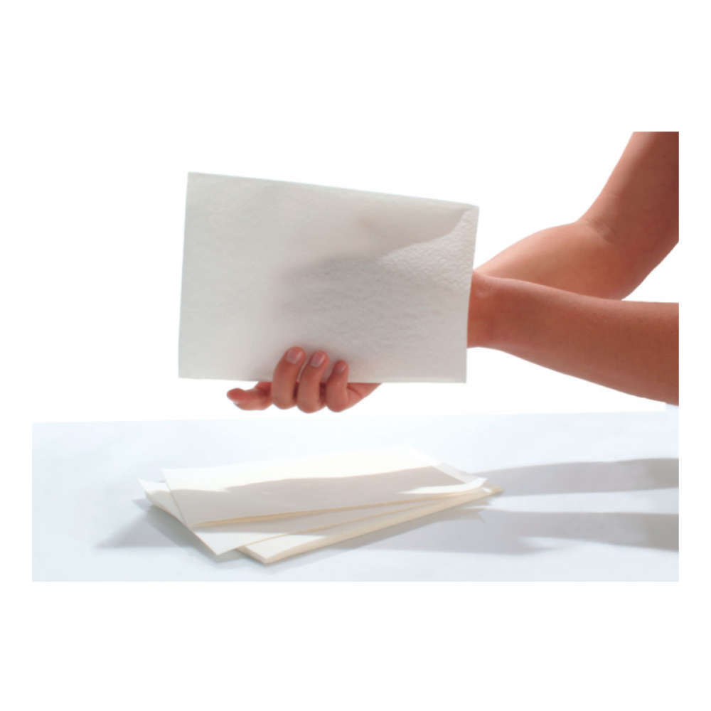 Eine Hand hält ein Laken, das dem Material der Seni Care Waschhandschuhe der TZMO Deutschland GmbH ähnelt. Darunter sind auf einem schlichten weißen Hintergrund mehrere ähnliche Laken verstreut.
