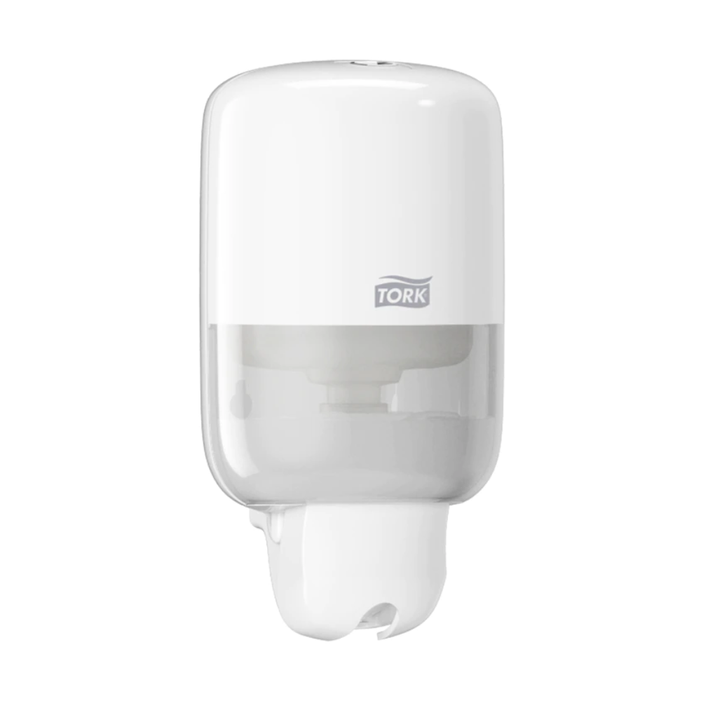 Der Tork 561000 Mini Spender für Flüssigseife Elevation S2 von TORK – Essity Professional Hygiene Germany GmbH ist ein moderner, weißer Seifenspender zur Wandmontage. Er verfügt über ein schlankes Design mit einem transparenten unteren Teil zur Anzeige des Flüssigseifestands und das Markenlogo ziert die obere Hälfte.