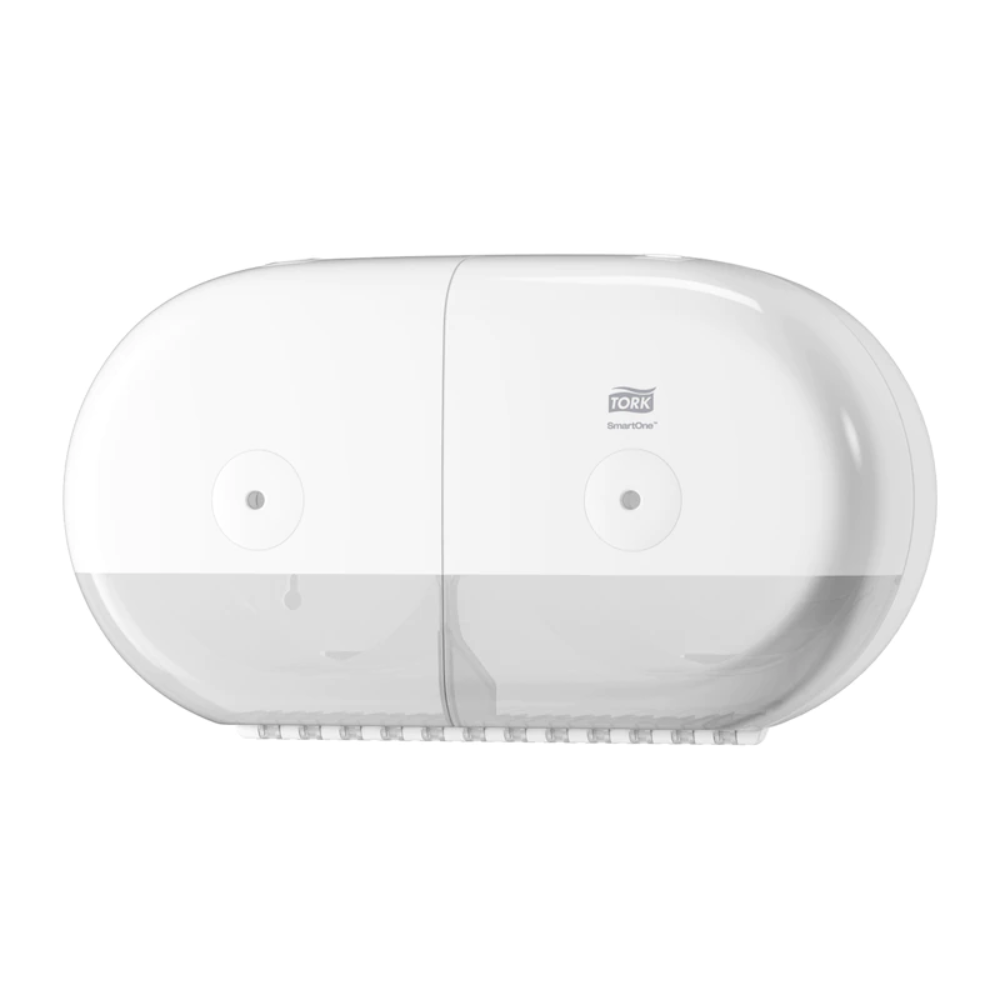 An der Wand ist ein Tork SmartOne® 682000 Mini Doppelrollenspender, hergestellt von TORK – Essity Professional Hygiene Germany GmbH, montiert. Dieser weiße, ovale Spender verfügt über einen transparenten unteren Teil und ist mit seinem glatten, modernen Aussehen speziell für die Aufnahme von Doppelrollen Toilettenpapier konzipiert.