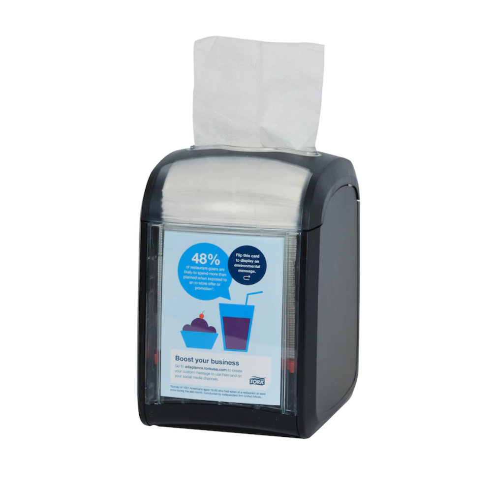 Der Tork Xpressnap Fit® 272900 Tischspender für Servietten von TORK - Essity Professional Hygiene Germany GmbH ist ein stilvoller Serviettenspender aus schwarzem Kunststoff mit einer transparenten Vorderseite, auf der Marketingmaterialien angezeigt werden. Mit einem teilweise sichtbaren Stapel weißer Servietten ist er für eine effiziente Serviettennutzung konzipiert und eignet sich daher ideal für jede Umgebung.