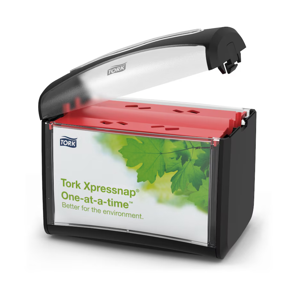 Ein schwarzer und durchsichtiger Tork Xpressnap® 272611 Tischspender für Servietten mit transparentem Deckel präsentiert rote Servietten im Inneren. Auf dem Etikett steht „Tork Xpressnap, einzeln – besser für die Umwelt“ und ein Bild mit grünen Blättern, das sowohl auf Hygiene als auch auf reduzierten Serviettenverbrauch hinweist.