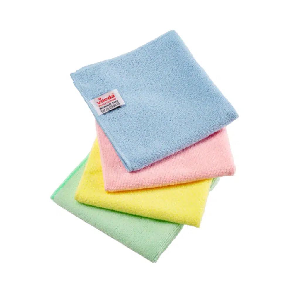 Drei Vileda Professional MicroTuff Base Mikrofasertücher in Pastelltönen – Blau, Rosa und Gelb – sind ordentlich auf einem grünen Hintergrund gestapelt. Am blauen Tuch ist ein kleines Etikett mit Text befestigt. Diese einfache Szene vor einem schlichten weißen Hintergrund entspricht den Standards des Nordic Swan Ecolabel.