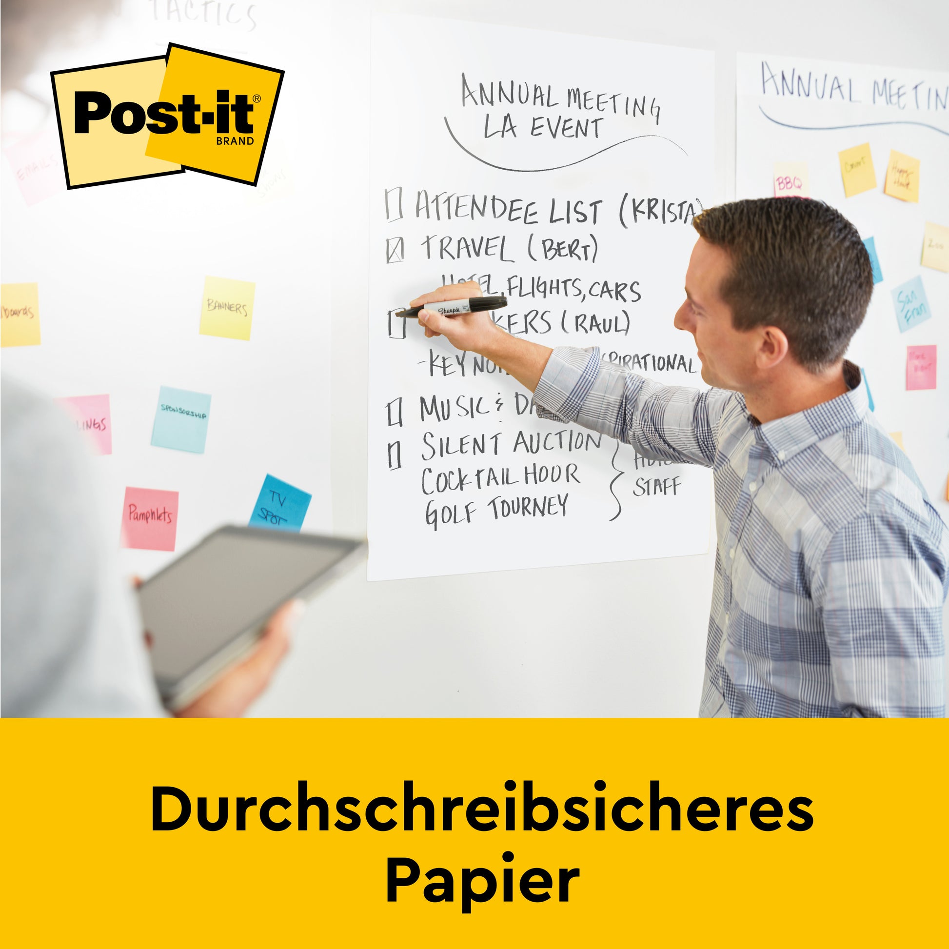 Ein Mann schreibt Tagesordnungspunkte für ein Meeting auf ein Post-it® Super Sticky selbsthaftendes Meeting Chart/Flipchart (63,5 x 76,2 cm, 30 Blatt/Block) von 3M Deutschland GmbH, während andere zuschauen. Bunte Haftnotizen sind an der Wand. Text: "Durchschreibsicheres Papier.