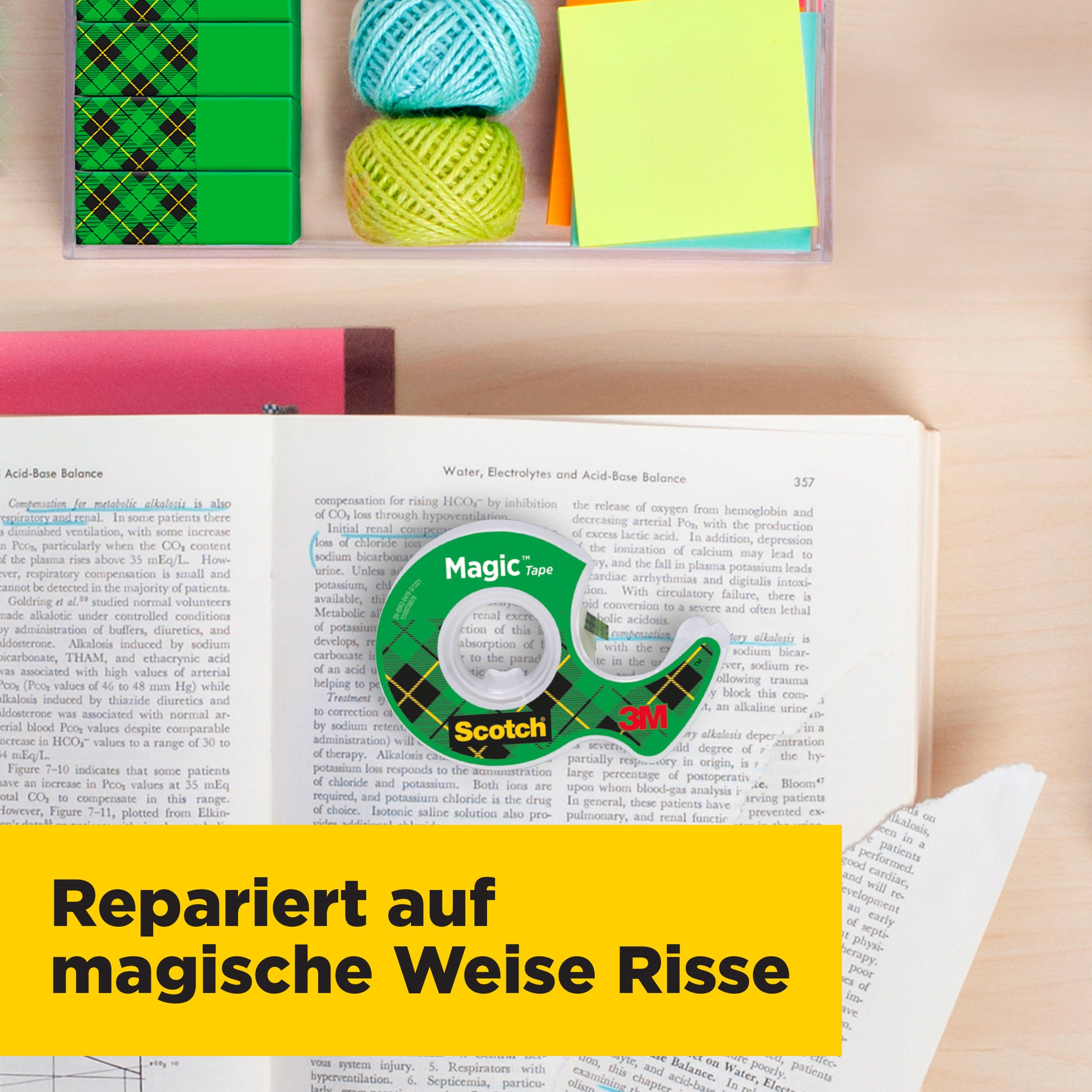 Eine Packung Scotch® Magic™ Unsichtbares Klebeband (1 Rolle, 19 mm x 25 m) von 3M Deutschland GmbH liegt auf einem offenen Buch neben farbigen Haftnotizen und Wollknäueln. Ein gelbes Banner sagt: "Repariert auf magische Weise Risse.