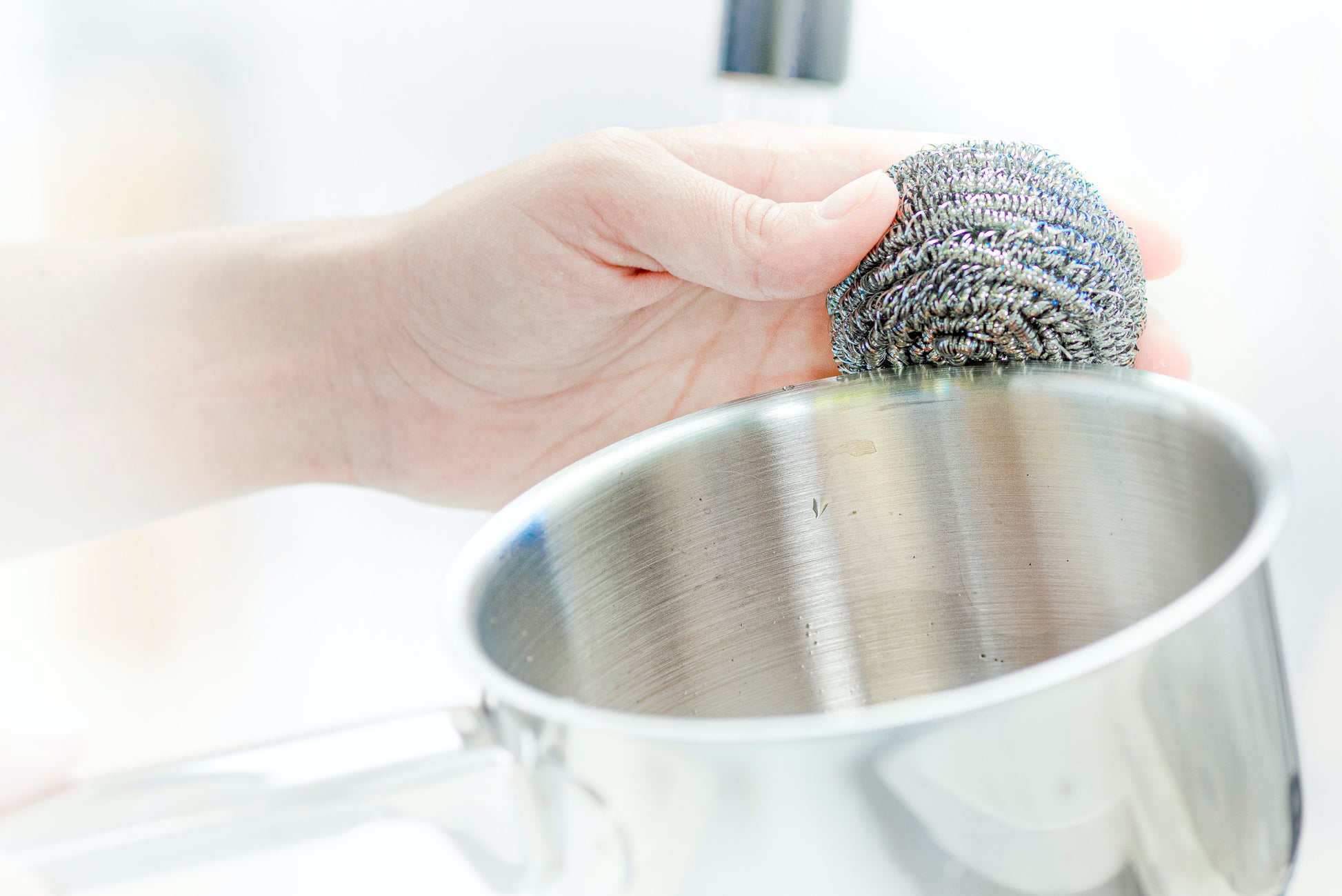 Eine Hand reinigt einen Kochtopf aus Edelstahl mit einer Scotch-Brite® Edelstahl-Spirale von 3M Deutschland GmbH, erhältlich im 3er-Pack.