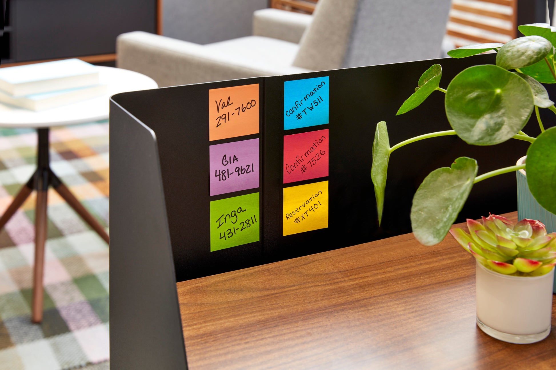 Ein weißer Post-it® Z-Notizenspender in Katzenform von 3M Deutschland GmbH mit rosafarbenen Super Sticky Z-Notes (76x76 mm, 90 Blatt) steht in einem Büro neben einem Holztisch mit einer Topfpflanze.