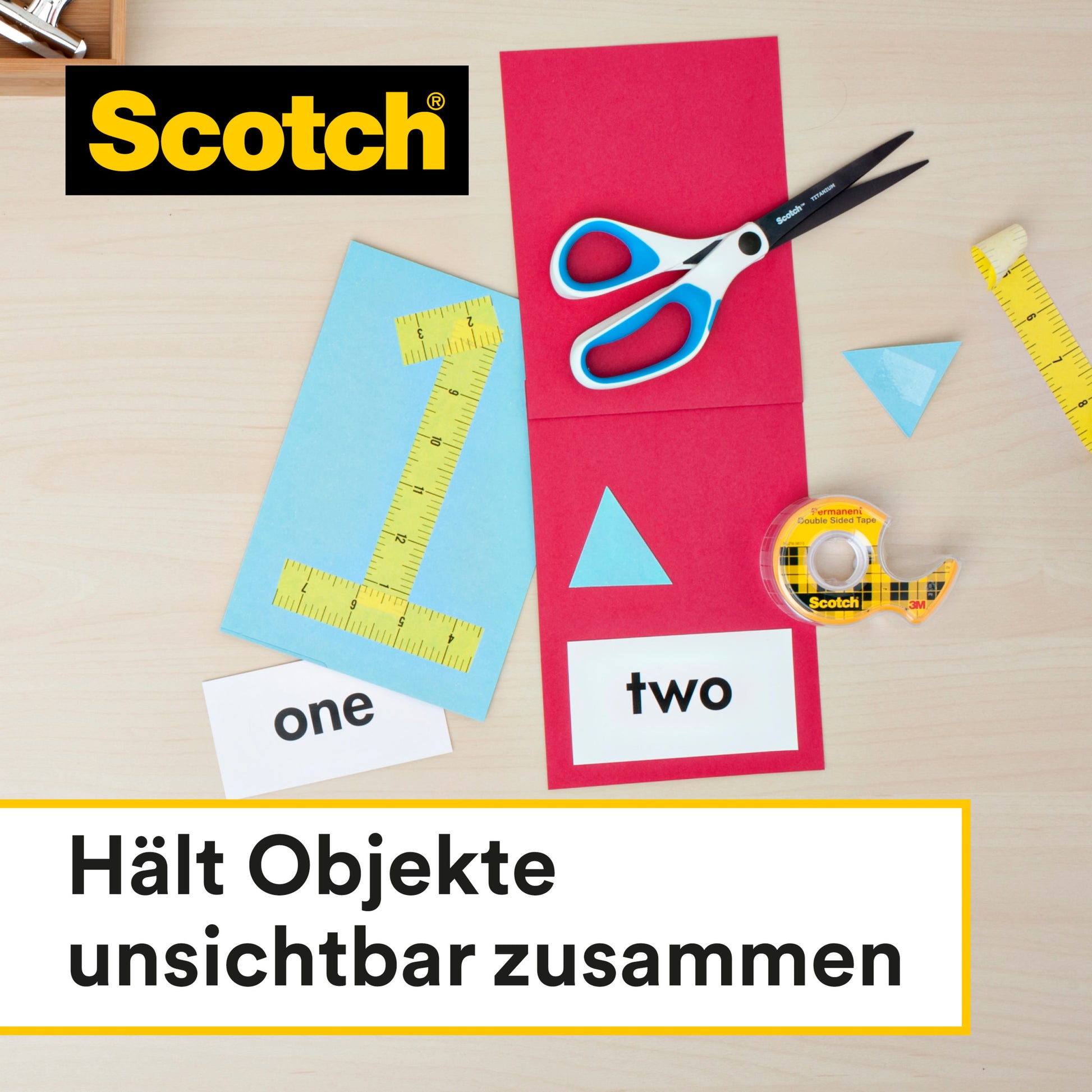 Eine Schere, ein Lineal und blaue Papierformen liegen neben Scotch® doppelseitigem Klebeband (2 Rollen, 12 mm x 6,3 m) von 3M Deutschland GmbH auf einer hellen Holzoberfläche. Der deutsche Text lautet: "Hält Objekte unsichtbar zusammen.