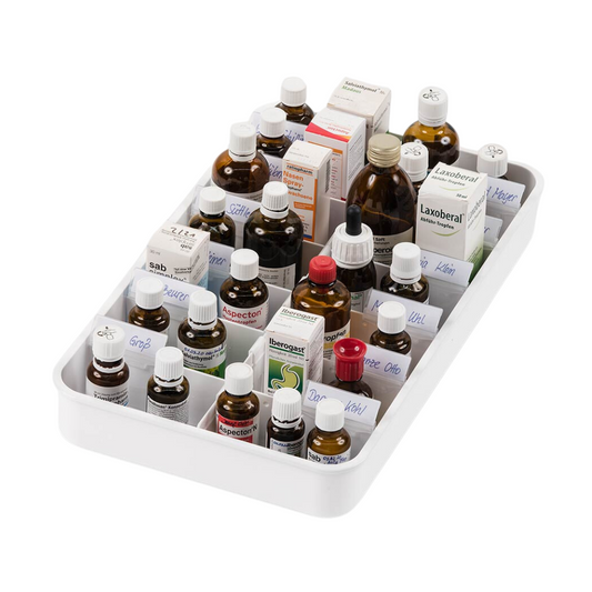 Die melipul Anbruchtropfen-Tablette mit 14 Fächern von Helmut Schwarz GmbH ordnet elegant eine Auswahl homöopathischer Flaschen und Schachteln und präsentiert eine übersichtliche Auswahl an Flüssigmedikamenten. Die Fächer enthalten Behälter in verschiedenen Größen und Farben, hauptsächlich braune Glasflaschen und weiße Schachteln, einige mit sichtbaren Etiketten.