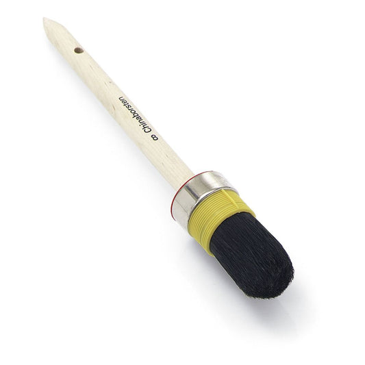 Der Nölle Profi Brush Handwerker-Ringpinsel verfügt über einen Holzgriff mit schwarzem Schriftzug, der Handwerkerqualität unterstreicht. Er hat eine Metallzwinge und ein gelbes Band mit rein schwarzen chinesischen Borsten.