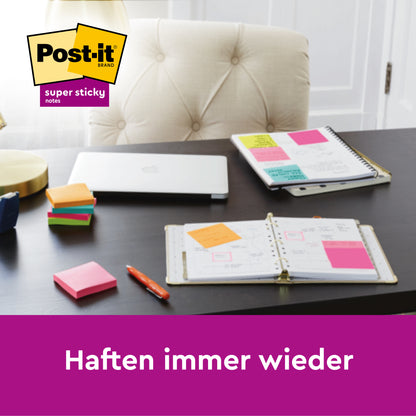 Ein Schreibtisch mit Notizbüchern, einem geschlossenen Laptop, einer Lampe, Stiften und bunten Post-it® Super Sticky Notes 6820S3 (76x76 mm) in neongrün, neonpink, ultragelb, ultragrün, ultrapink von 3M Deutschland GmbH. Text: "Haften immer wieder." Logo oben links.