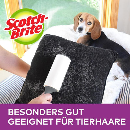 A hand uses the Scotch-Brite™ Pet Extra Sticky* Replacement Roll for Pet Hair (48 sheets, 1/pack) from 3M Deutschland GmbH to remove pet hair from a black cushion, highlighting "Especially good for pet hair."