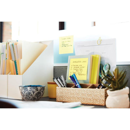 A tidy desk with 3M Post-it® Super Sticky Notes (101x101 mm, 90 sheets, 100% PEFC), file folders, a patterned bowl, a woven basket for pens and scissors, and papers by the window.