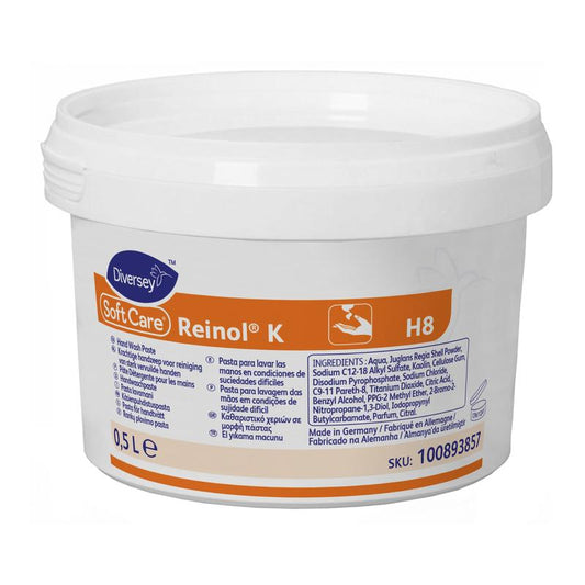 Ein 0,5-Liter-Behälter aus weißem Kunststoff mit Soft Care Reinol K Handwaschpaste von Diversey Deutschland GmbH & Co. OHG verfügt über ein orange-weißes Etikett mit mehrsprachigen Gebrauchsanweisungen für die sanfte Pflege hartnäckiger Verschmutzungen.
