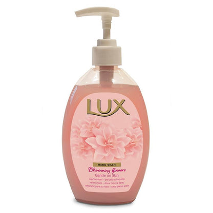 A transparent plastic bottle of LUX Pro Formula Hand-Wash Soap by Diversey Deutschland GmbH & Co. OHG, with pink liquid, white pump, floral graphic and the inscription "Blooming Flowers Gentle on Skin" - skin-friendly with a pleasant scent.