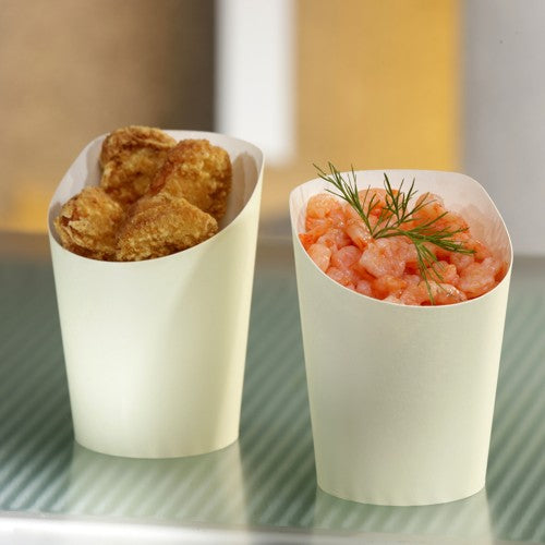 Zwei beige PAPSTAR 75 Snackbecher aus Papier, einer mit panierten Frikadellen, der andere mit Garnelen und Dill, stehen auf Streifen für eine umweltfreundliche Serviermöglichkeit. Marke: PAPSTAR GmbH. Fassungsvermögen: 0,16 l, Ø 7,5 cm, Höhe: 9,9 cm (75 Stück).
