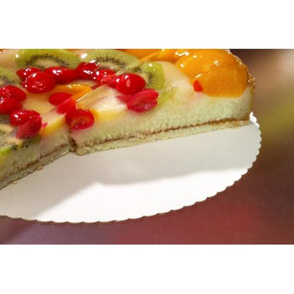 A cake decorated with fruit and a cookie cutter lies on a PAPSTAR 100 cake stands, "pure" cardboard from the PAPSTAR GmbH. Topped with kiwi, cherries, and peaches on a gelatin base, it’s a testament to quality—perfect for the foodservice industry.